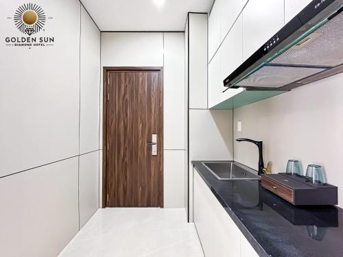 a kitchen with a sink and a wooden door at Golden Sun Hotel Apartments 5 in Ho Chi Minh City