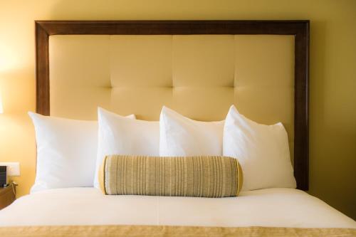 a bed with white pillows and a wooden headboard at The Edgewater in Madison