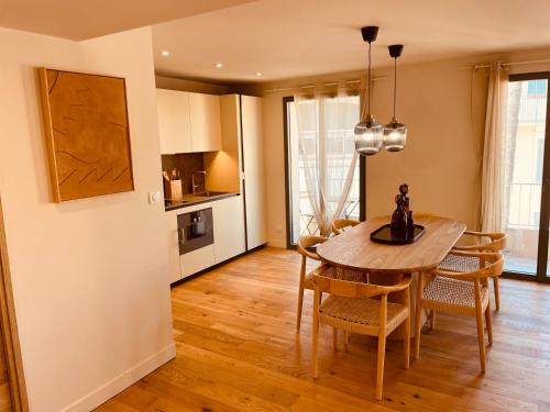 a kitchen and dining room with a table and chairs at La Maison Cavet 5 Appartements de standing au cœur du village in Sanary-sur-Mer