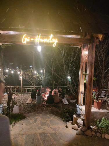 a group of people sitting under a sign at night at Gio Homestay & Bungalow Sapa in Sa Pa