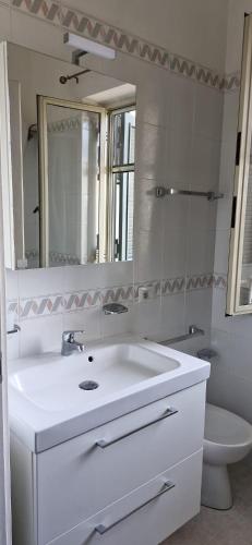 a bathroom with a sink and a mirror and a toilet at Giaro's Home in Pompei