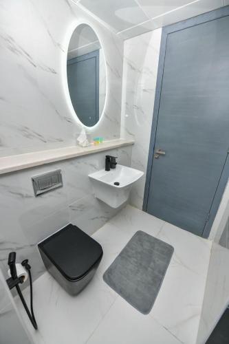 a bathroom with a toilet and a sink and a mirror at Harf-7821 Townhouse - Raha Gardens in Abu Dhabi