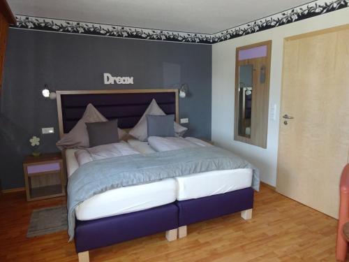 a bedroom with a large bed with a blue comforter at Haus Meeresblick in Heiligenhafen