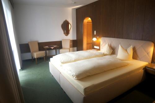 a bedroom with a large white bed in a room at Hotel Sonnhof in Innsbruck