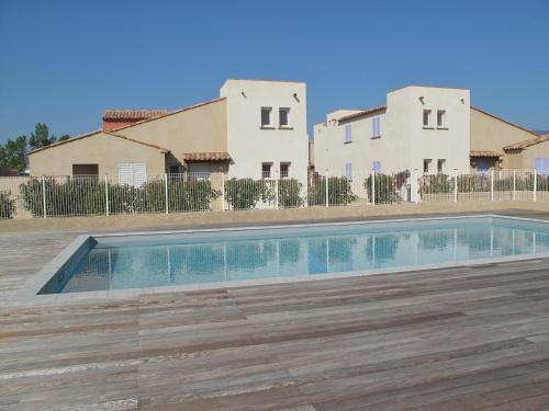 - une piscine en face de deux maisons dans l'établissement Résidence Tamaris 2, à Porto-Vecchio