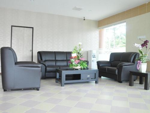 a waiting room with two leather chairs and a table at Loong Fatt Hotel in Sungkai