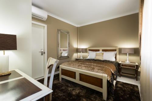 a bedroom with a bed and a table and a desk at House Barra Beach in Praia da Barra