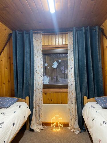 a bedroom with two beds and a window with a fish tank at Viridian Three Accommodation, Three Winds in Divčibare