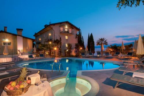 a villa with a swimming pool at night at Hotel Galvani in Torri del Benaco