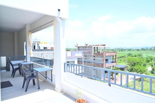 a balcony with a table and chairs and a view at Gopi Abode Hampi in Hampi