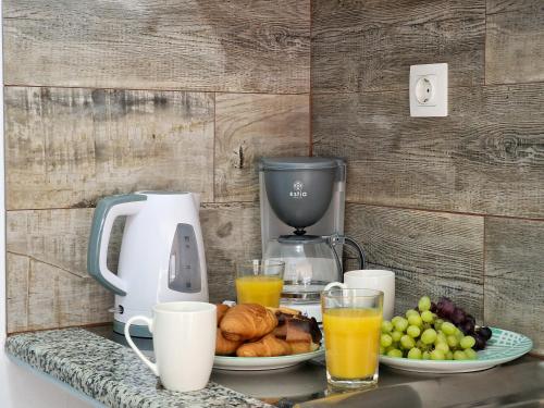 a table with a coffee maker and a plate of fruit at Australia Apartments in Kalymnos