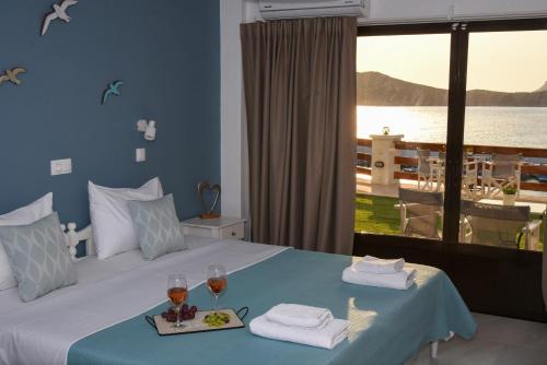 a bedroom with a bed with two glasses of wine at Australia Apartments in Kalymnos