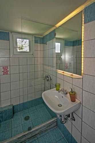 a bathroom with a sink and a mirror at Fraskoula's Town in Mikonos