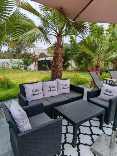 a patio with a table and chairs and a palm tree at Villa Aronora in Essehoul