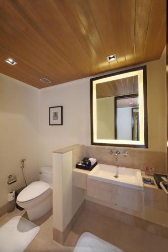 a bathroom with a toilet and a sink and a mirror at The Oberoi Mumbai in Mumbai