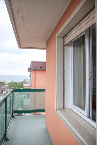 a balcony of a building with an open window at Hotel Europeo in Sottomarina