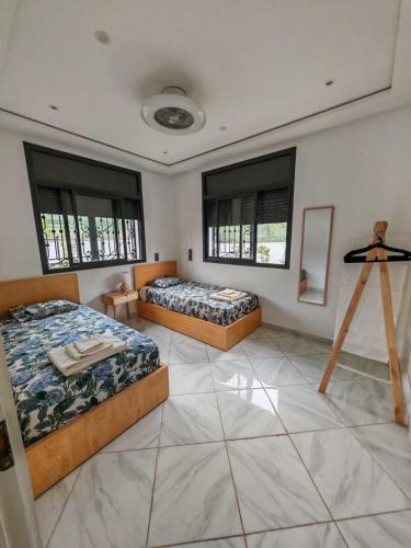 two beds in a large room with windows at Villa Aronora in Essehoul
