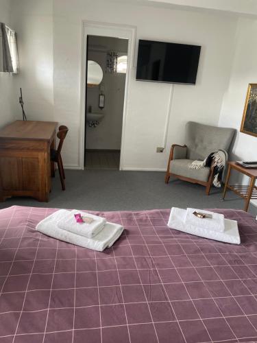a room with two towels on a purple bed at Bjerremark Hotel og Kursuscenter in Tønder