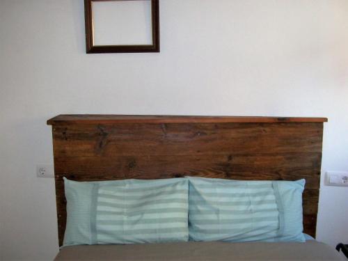 a bed with a wooden headboard and a mirror at Luna11 in Alcañiz