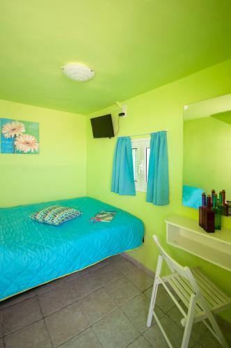 a bedroom with a bed with blue sheets and a desk at Fraskoula's Town in Mikonos