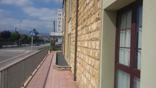 a brick building with a red door next to a street at Hotel Alameda in Villaviciosa