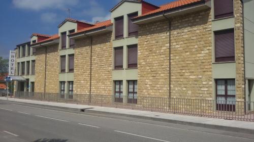 a row of brick buildings on the side of a street at Hotel Alameda in Villaviciosa