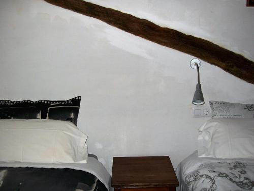 a bedroom with two beds and a lamp on the wall at Luna11 in Alcañiz