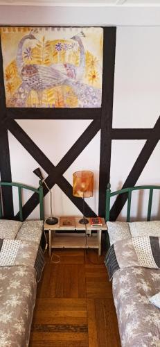 a room with two beds and a painting on the wall at Agroturystyka Stajnia Dorado Pokoje Gościnne i Apartamenty in Leoncin