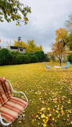 two blue chairs sitting in a field of leaves at Skardu Baltistan Village Guest House in Skardu