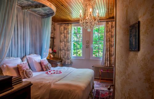 a bedroom with a large bed with a chandelier at Château de l'Abbaye - Teritoria in Moreilles