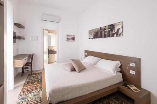 a bedroom with a bed and a table and a desk at Dimora Del Dragone in Vieste