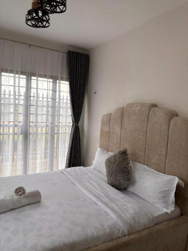 ein Schlafzimmer mit einem großen Bett und einem großen Fenster in der Unterkunft Sparkles B&Bs in Nairobi