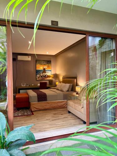 a bedroom with a bed and a couch at Puri Sabina Bed & Breakfast in Jimbaran
