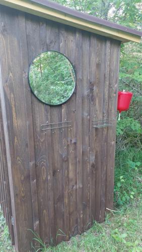 a wooden fence with a round window on it at Jaagu Metsatelk neljale in Suuremõisa