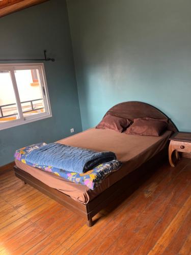a bed in the corner of a room with a window at Appartement Antananarivo - Palais de la Reine, Rova in Mandriankeniheny