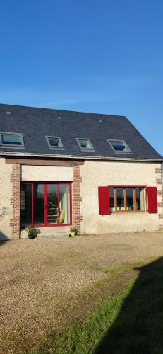 a brick house with red doors and a black roof at Gîte des Toucanes in Beaumont-Pied-de-Boeuf