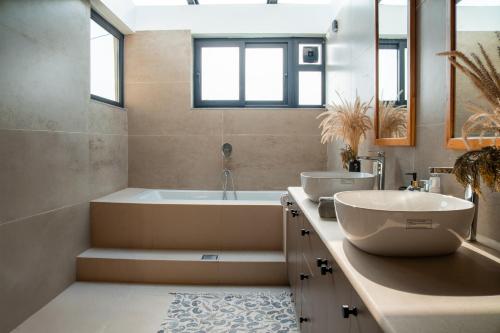 a bathroom with a tub and a sink and a bath tub at Jaadooghar The Chitai Life in Almora