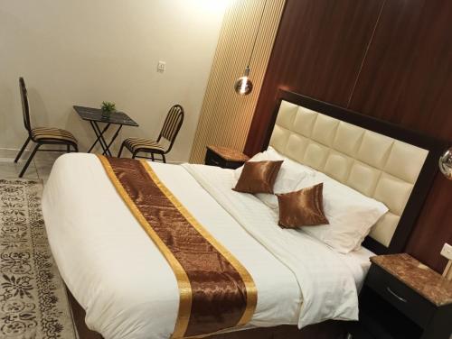 a bedroom with a large bed with a large white bedspread at دار السلام للشقق المخدومة الجوف دومة الجندل in Dawmat al Jandal