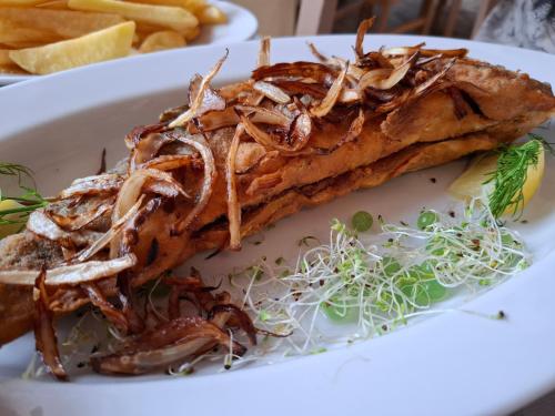 a plate of food with a piece of meat at Apartamenty Młyn in Męcikał