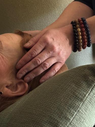 a woman with a rosary on her neck next to a couch at Hotelli Unelma in Kullaa