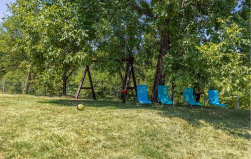 a group of chairs sitting in a field under a tree at 1 Bedroom Amazing Home In Ozalj in Ozalj