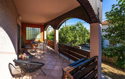 an outdoor patio with chairs and a table at Beautiful Home In Starigrad - Paklenica With Wifi in Starigrad-Paklenica