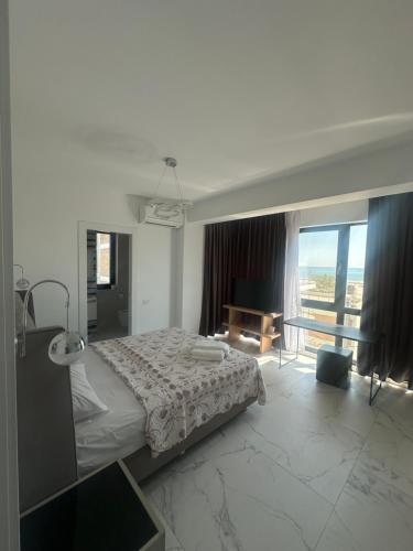 a bedroom with a bed and a large window at ELIZ Luxury Residence in Mamaia