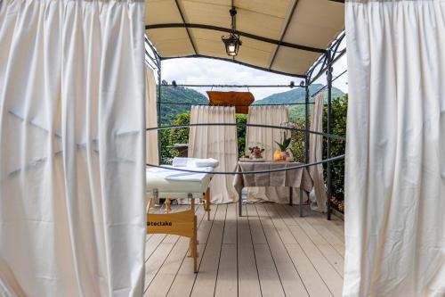 a patio with white curtains and a table and a chair at Villa Vitali - Bellagio in Bellagio