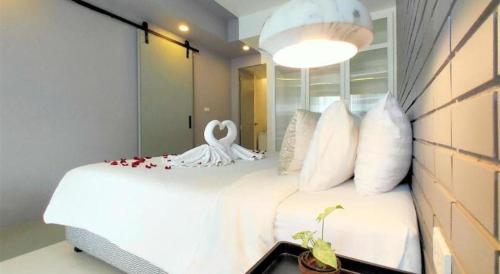 a bedroom with a bed with a swan on it at Silom Studios in Bangkok