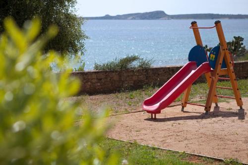 a playground with a slide next to the water at Dialiskari Villas in Marathopolis