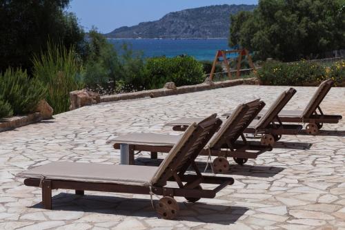 a row of lounge chairs on a patio with a playground at Dialiskari Villas in Marathopolis