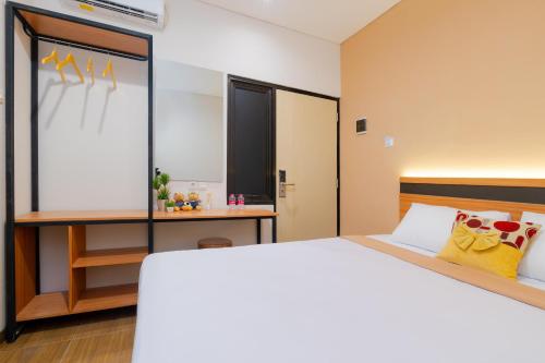 a bedroom with a large bed and a desk at Grand Valora Puspowarno Kostel in Kalibanteng-lor