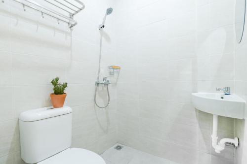 a white bathroom with a toilet and a sink at Grand Valora Puspowarno Kostel in Kalibanteng-lor