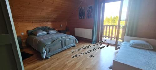 a bedroom with two beds and a balcony at gîte des 1000 étangs in Saint-Bresson
